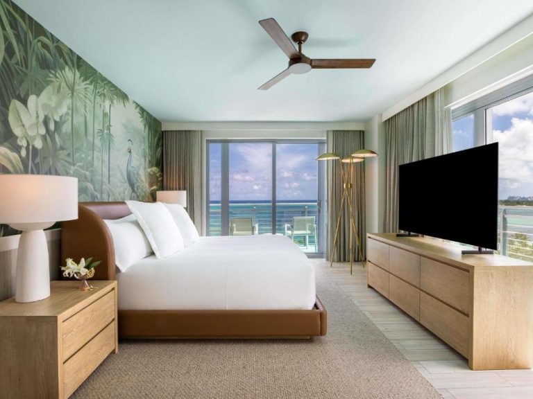 Habitación con cama king, mural tropical y vista panorámica al mar turquesa en SLS at Baha Mar