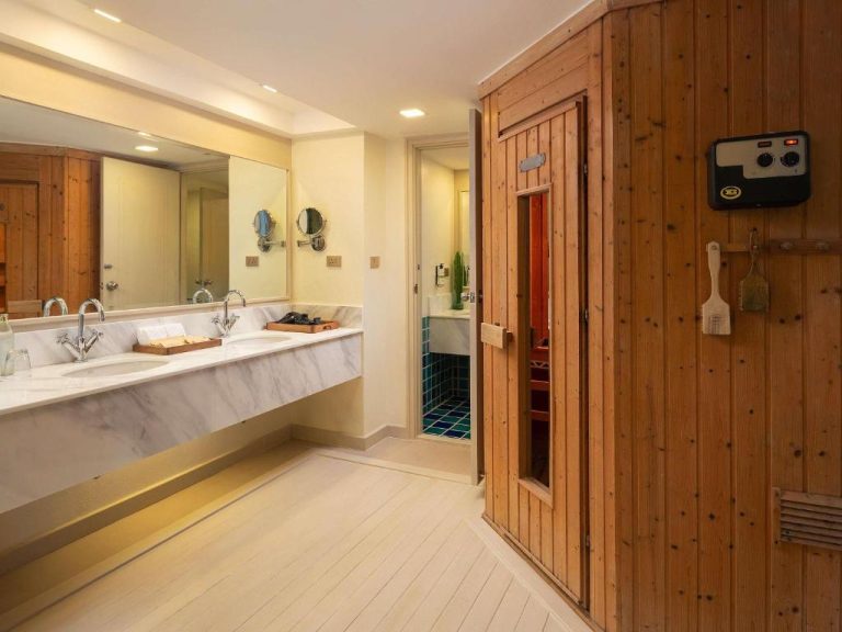Baño de lujo con doble lavabo en mármol y sauna privada de madera en Pullman Pattaya Hotel G