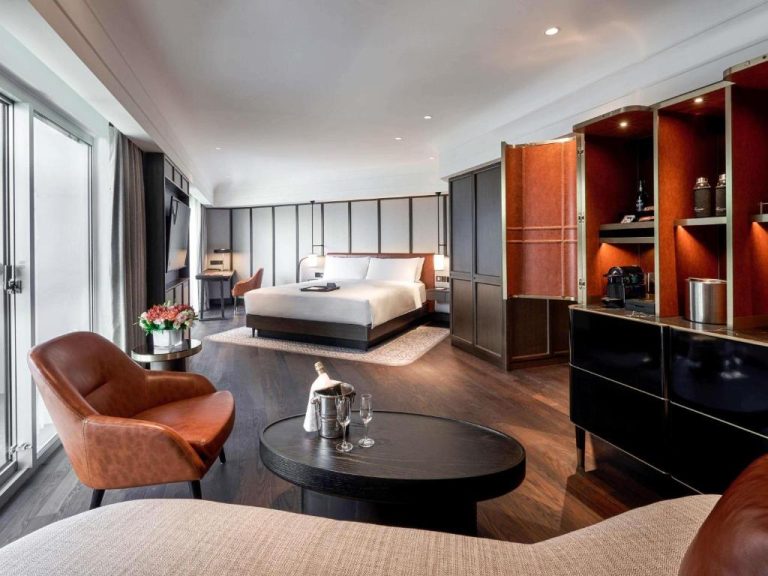 Suite de lujo con salón, cama king y minibar en el Fairmont Singapore con diseño contemporáneo
