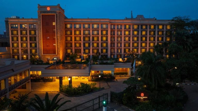Fachada exterior iluminada del Nairobi Serena Hotel en Kenia durante la noche con jardines tropicales