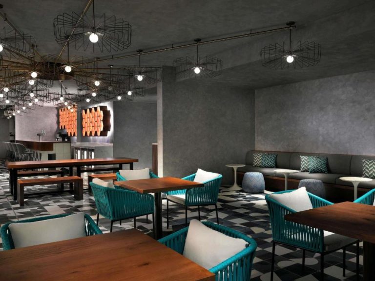 Restaurante lounge moderno con sillas turquesas y lámparas decorativas en Mövenpick Hotel Ghala Muscat