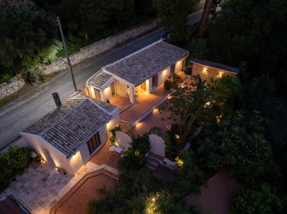Vista aérea nocturna de la villa Aritis 3 con iluminación exterior y jardín mediterráneo