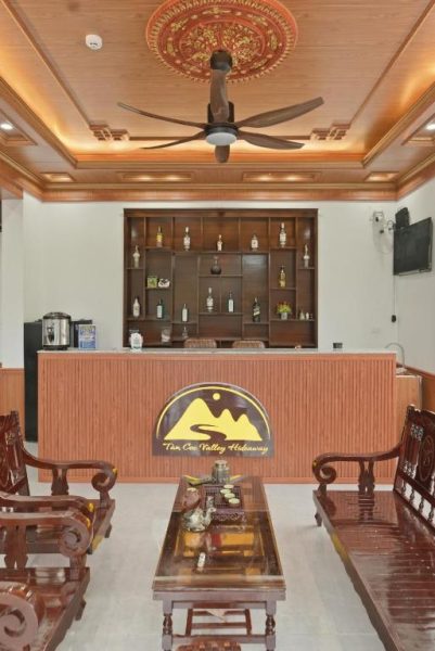 Recepción y bar del Tam Coc Valley Hideaway con mobiliario de madera y ventilador de techo decorativo