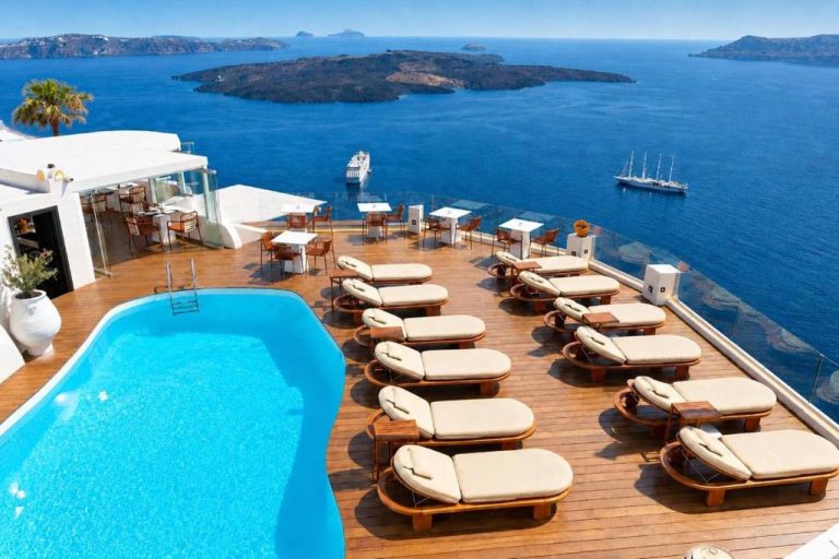 Piscina infinita con tumbonas y vistas a la caldera volcánica del mar Egeo en Sun Rocks Boutique Hotel Santorini