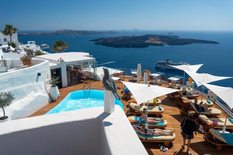Terraza con piscina y tumbonas del Sun Rocks Boutique Hotel con vistas a la caldera de Santorini