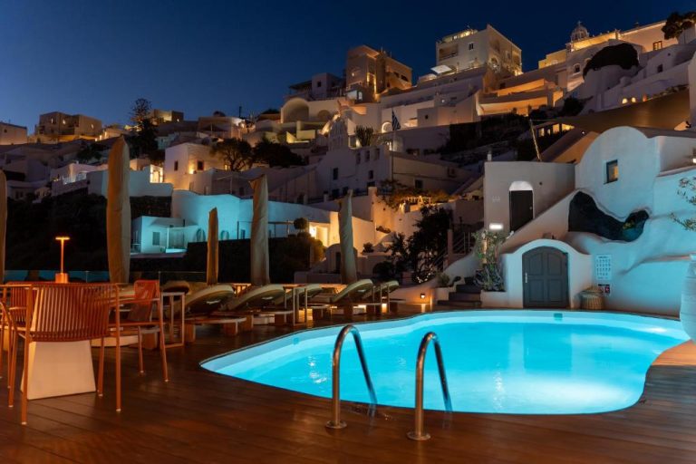 Piscina iluminada de noche con vistas a la caldera en Sun Rocks Boutique Hotel de Santorini
