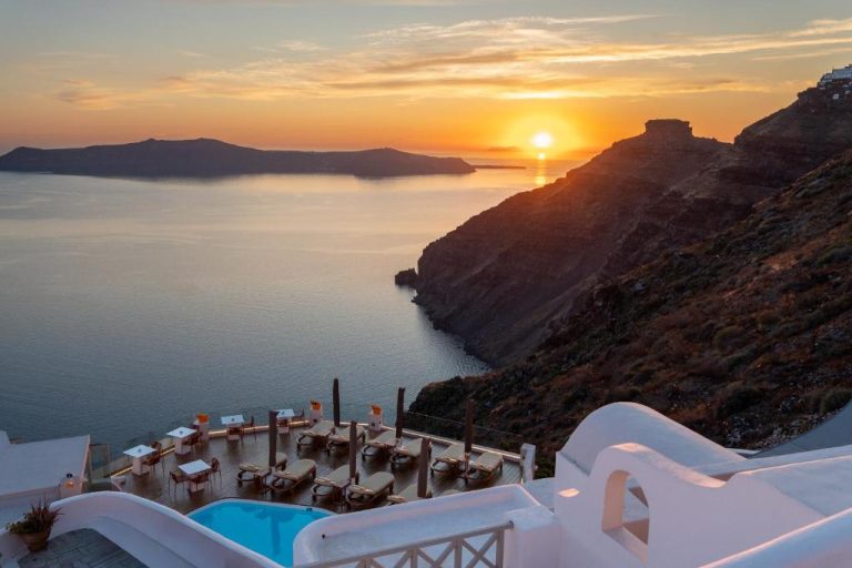 Terraza con piscina y tumbonas del Sun Rocks Boutique Hotel con vistas a la caldera de Santorini al atardecer