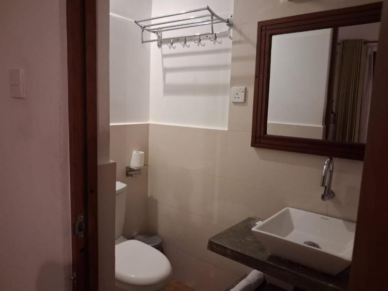 Baño completo con lavabo, inodoro y espejo del Hotel River Tree Bolgoda