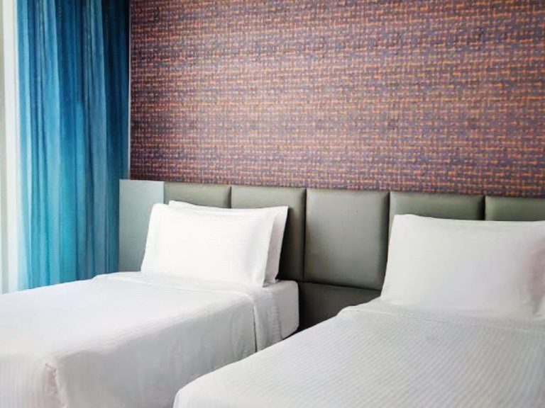 Habitación twin con dos camas individuales y cabecero verde en The Manito Seaview Suites