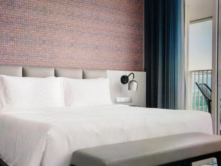 Habitación con cama doble y vistas al mar en The Manito Seaview Suites con decoración moderna