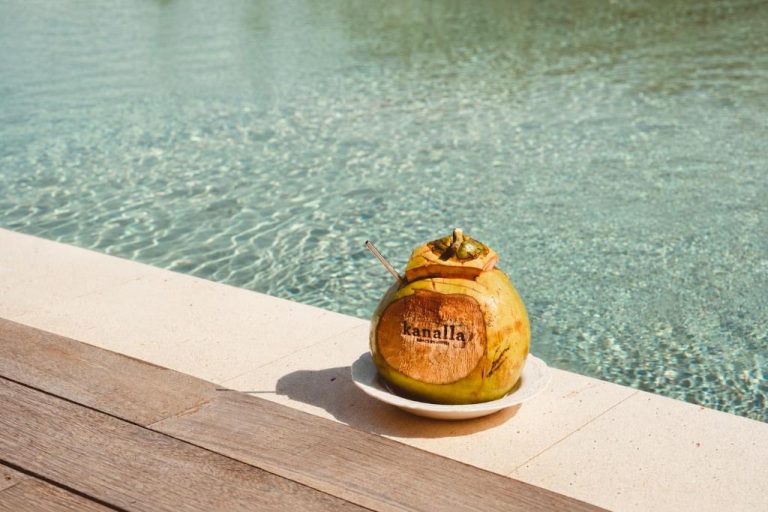 Coco fresco con pajita junto a la piscina del Kanalla Boutique Hotel, perfecta bebida tropical de verano