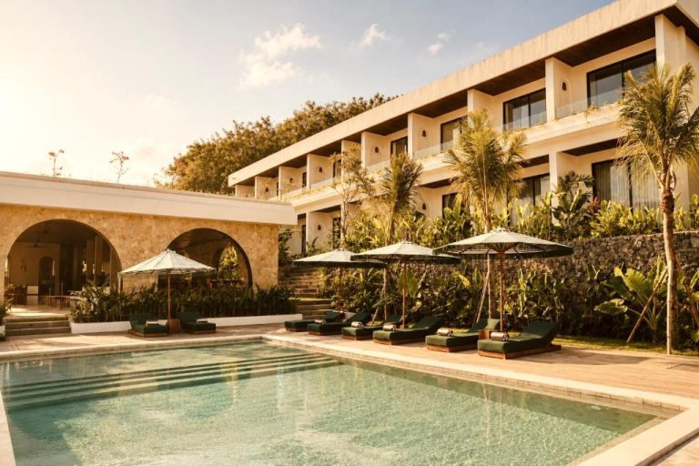 Piscina exterior con tumbonas y palmeras del Kanalla Boutique Hotel rodeada de vegetación tropical