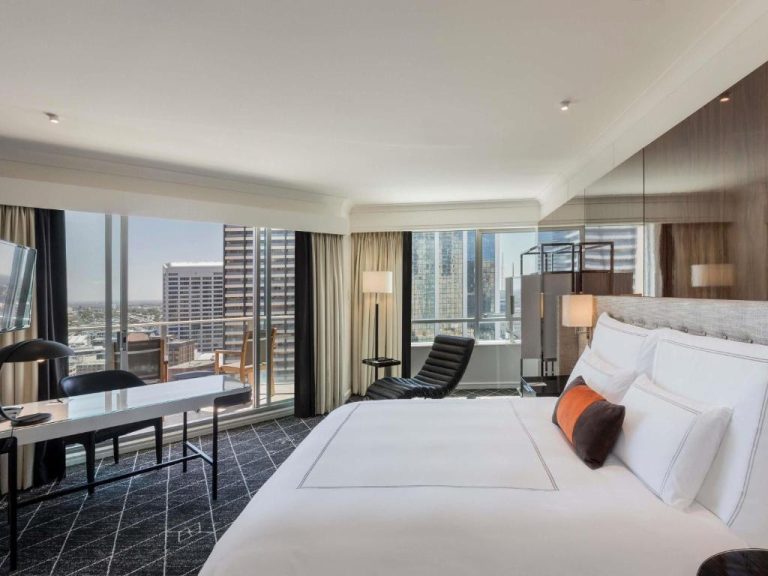 Habitación deluxe con cama king y vistas panorámicas al skyline de Sídney en Swissotel Sydney