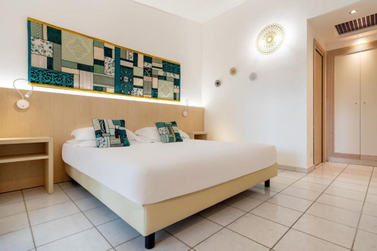 Habitación doble con cama matrimonial y decoración patchwork en Hotel Corte Rosada Adults Only Meliá