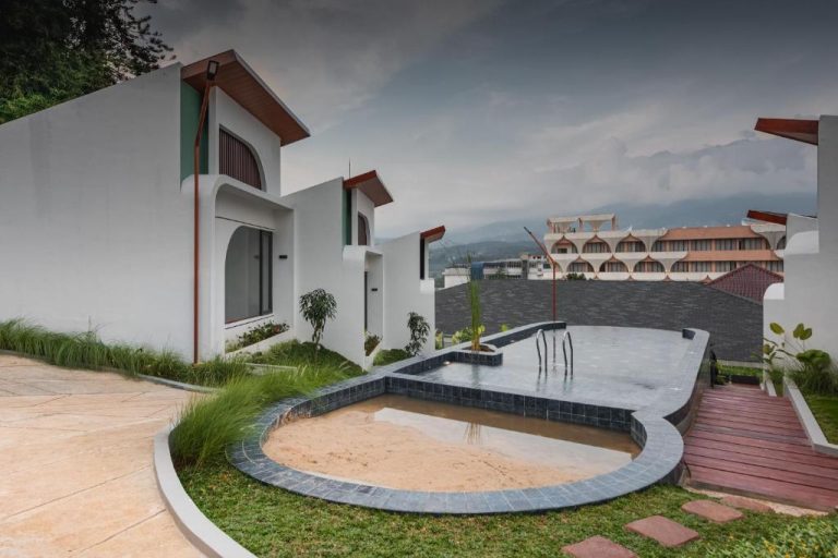 Piscina exterior con jardín y villas del Anaya Azana Hotel & Villa en Tawangmangu con vistas a la montaña