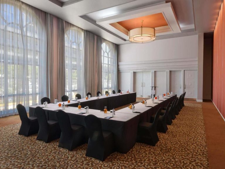 Sala de conferencias en forma de U con sillas negras y mesas blancas en Pullman Nairobi Upper Hill