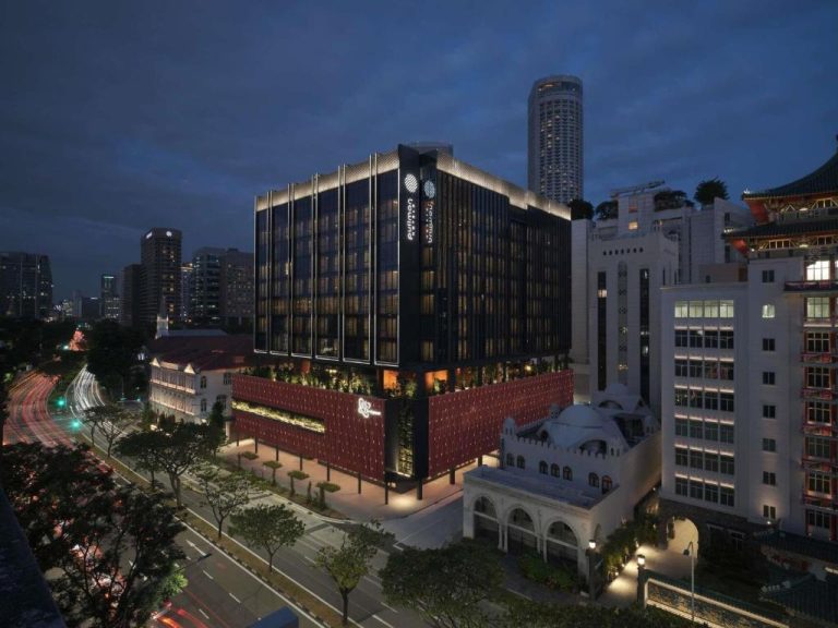 Vista nocturna de la fachada exterior del Pullman Singapore Hill Street con iluminación urbana