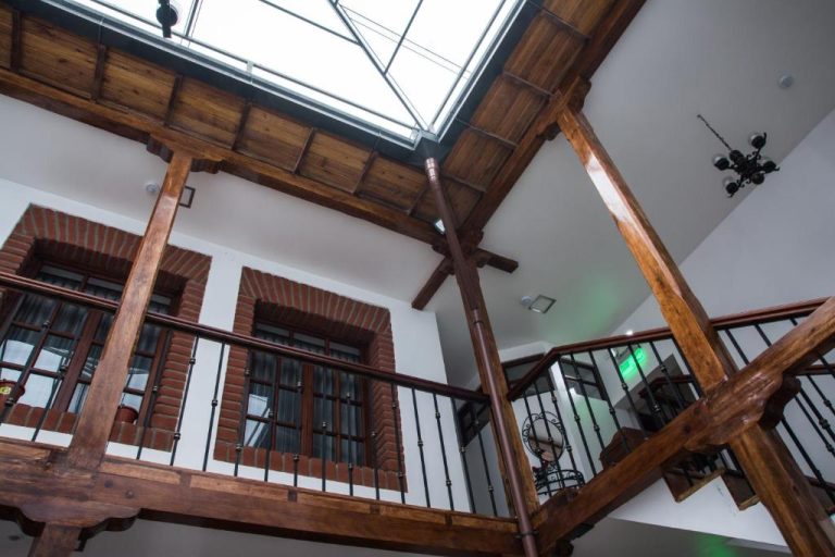 Patio interior con balcones de madera y tragaluz del Hotel Casa Ecuatreasures Centro Histórico
