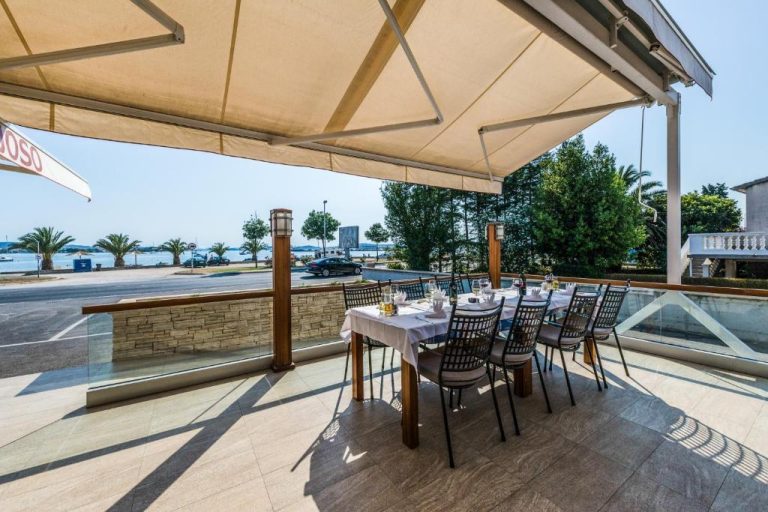 Terraza exterior del Hotel Joso con mesa preparada y vistas al mar en un día soleado