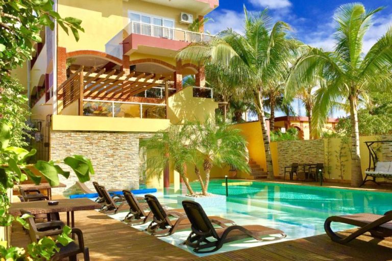 Piscina exterior con tumbonas y palmeras tropicales del Sosua Inn Hotel en República Dominicana