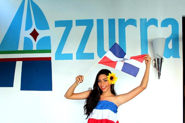 Animadora del Aparta Hotel Azzurra con bandera dominicana y vestido tricolor celebrando en el hotel