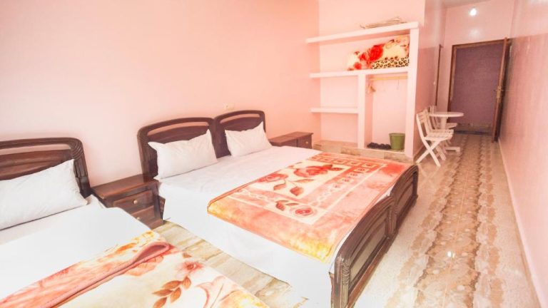 Habitación triple con tres camas y decoración en tonos rosas del Kasbah Hotel Camping Jurassique