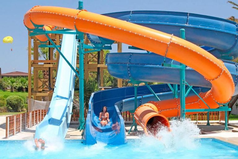 Toboganes acuáticos de colores naranja y azul con piscina en Sahara Beach Aquapark Resort