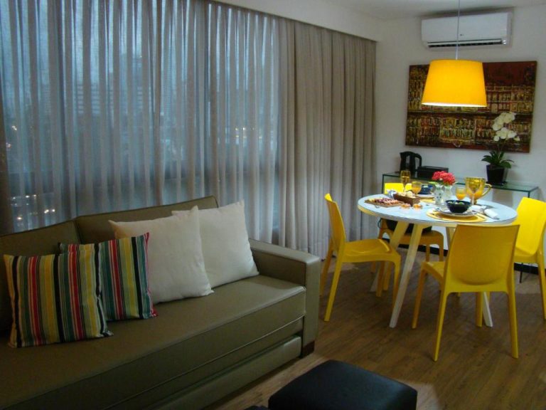 Sala de estar y comedor moderno con sillas amarillas y sofá en Flat 508 Recife