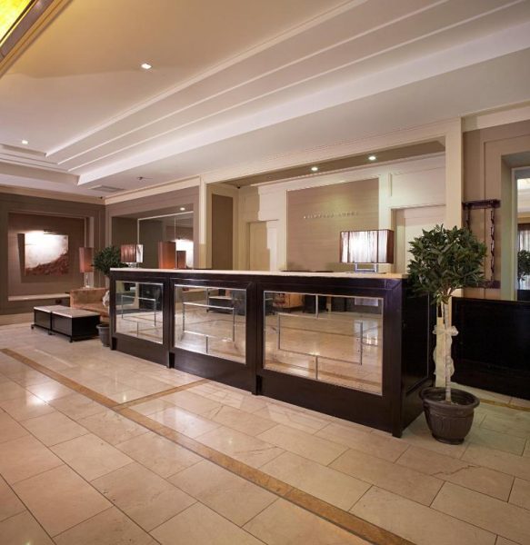 Recepción principal con mostrador elegante y suelo de mármol del Shamrock Lodge Hotel