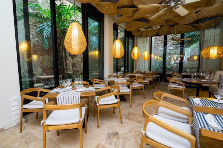 Restaurante interior con mesas de madera y lámparas de ratán del Movich Hotel Cartagena de Indias