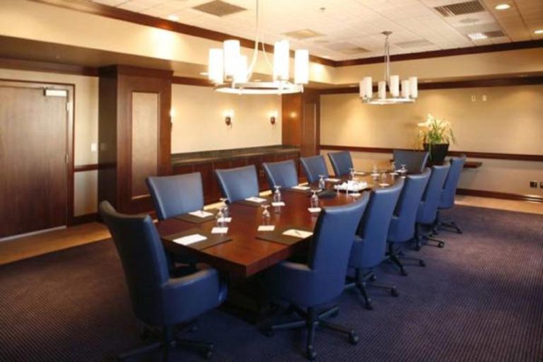 Sala de reuniones ejecutiva con mesa de conferencias y sillas azules en The Platinum Hotel