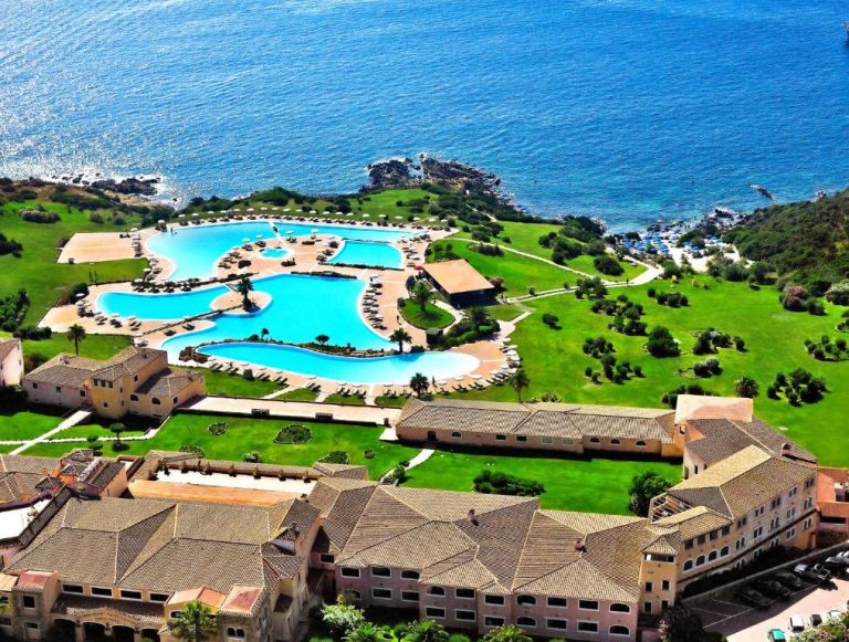 Vista aérea de las piscinas exteriores del Colonna Resort Porto Cervo con jardines y acceso al mar de Cerdeña