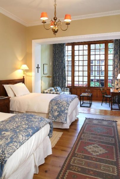 Habitación twin clásica con dos camas y ventanales de madera en Hotel Casa Real Viña Santa Rita