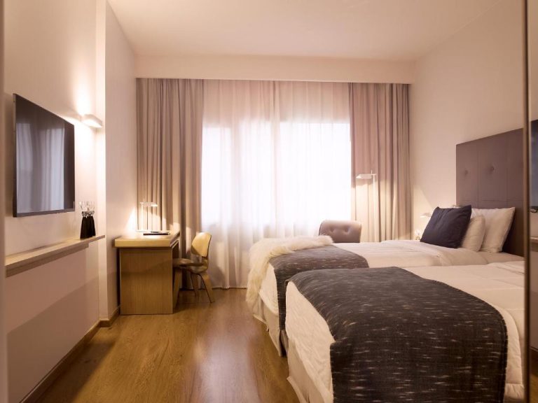 Habitación twin con dos camas y escritorio de trabajo en Dazzler by Wyndham Asunción