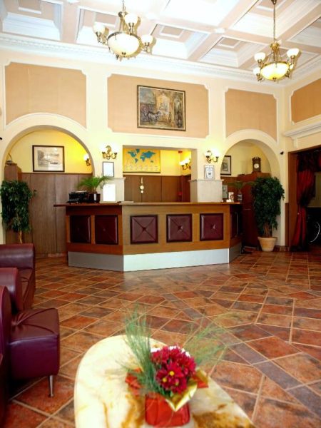 Recepción principal del Hotel Anna-Kristina con mostrador de madera y decoración clásica elegante