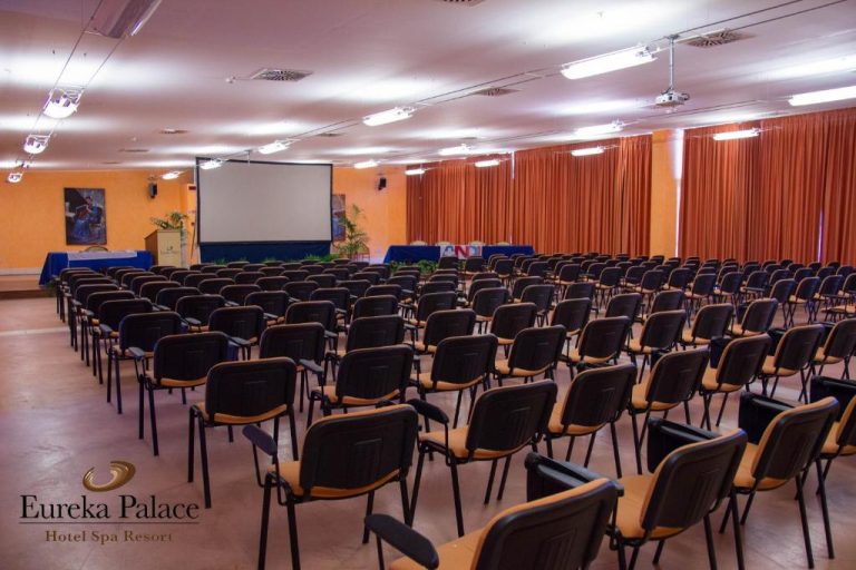 Sala de conferencias con sillas y pantalla de proyección en Eureka Palace Hotel Spa Resort