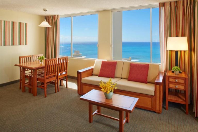 Sala de estar con sofá, mesa de comedor y vistas al océano Pacífico en el Pacific Monarch Hotel