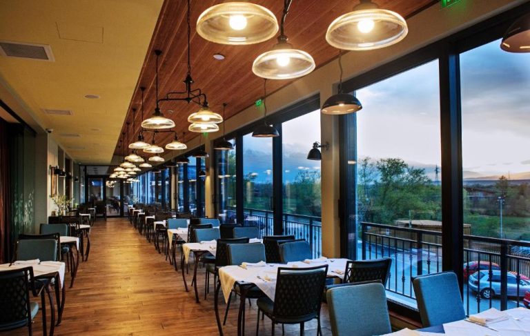 Restaurante panorámico con vistas al exterior y mesas elegantes en Hot Springs Medical and SPA