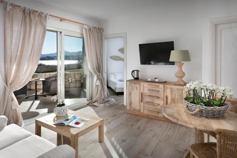 Salón luminoso con terraza y vistas al mar en Gabbiano Azzurro Hotel & Suites en Cerdeña