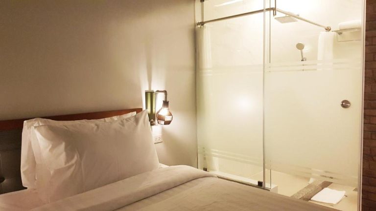 Habitación doble con ducha de cristal integrada y cama matrimonial en el Hotel GQ Plaza