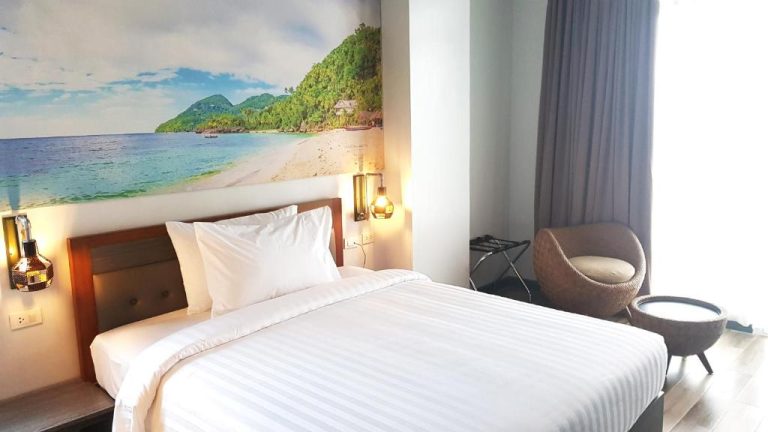 Habitación doble con cama king size y mural de playa tropical en el Hotel GQ Plaza