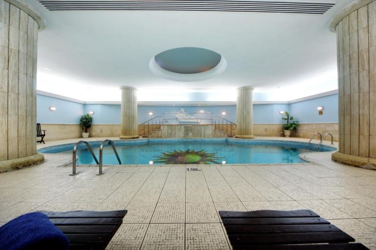 Piscina interior climatizada con columnas clásicas y jacuzzi del Vivaldi Hotel