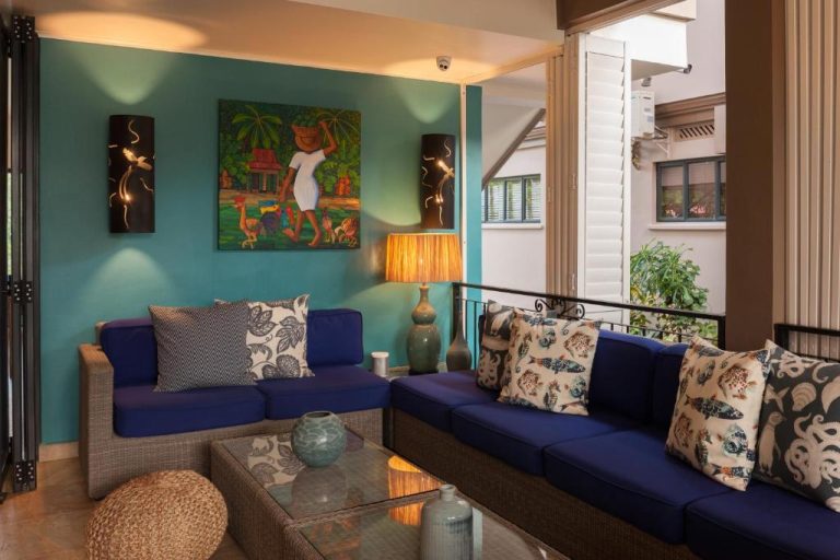 Salón tropical con sofás azules y decoración caribeña en Le Repaire Boutique Hotel & Restaurant