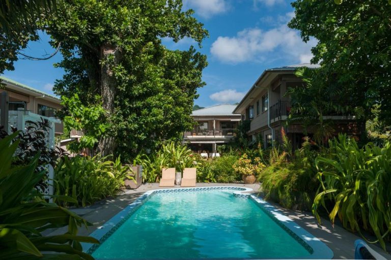 Piscina exterior rodeada de jardín tropical en Le Repaire Boutique Hotel & Restaurant en Seychelles