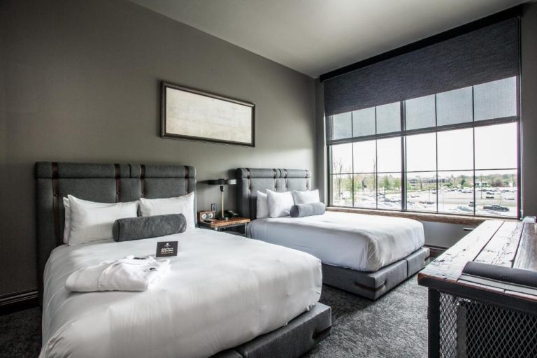 Habitación doble con diseño industrial y gran ventanal en Ironworks Hotel Indy Indianapolis