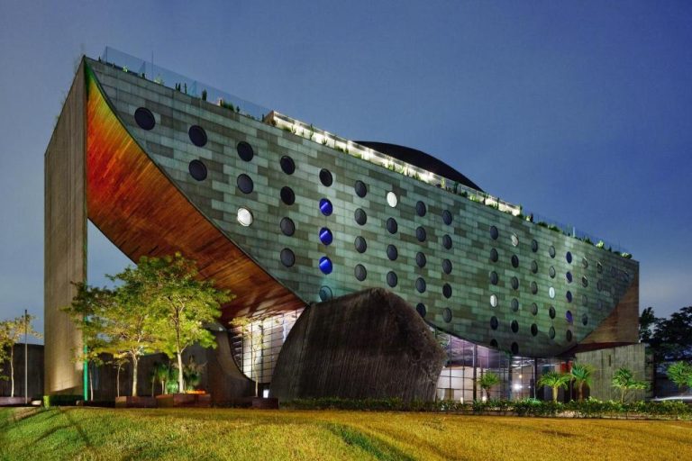 Fachada exterior del Hotel Unique de São Paulo iluminada de noche con su icónica arquitectura curva y ventanas circulares
