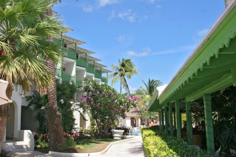Jardines tropicales con palmeras y bungalows del hotel Mango Bay All Inclusive en Barbados