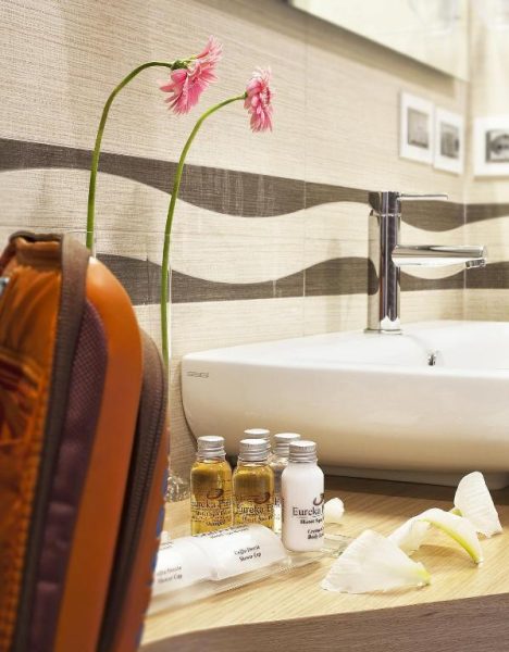 Amenities de baño y productos de spa del Eureka Palace Hotel Spa Resort con flores decorativas