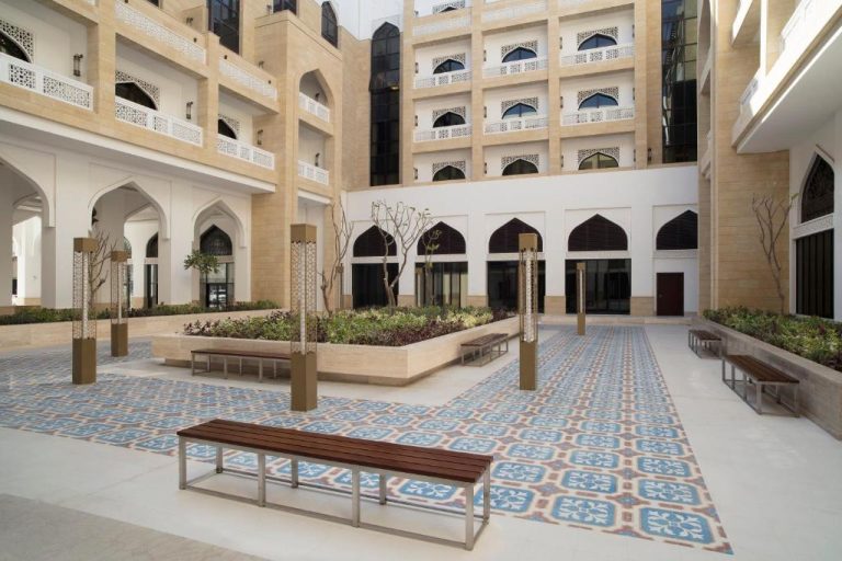 Patio interior con arcos árabes y jardines del Al Najada Doha Hotel Apartments by Oaks en Qatar