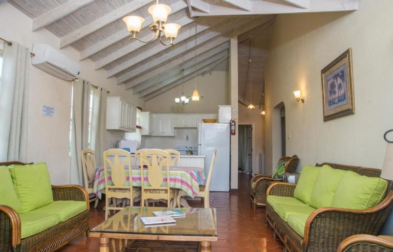 Sala de estar con sofás verdes y cocina americana abierta en Best E Villas Prospect St James